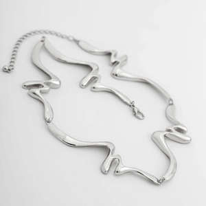 Detalle de collar de metal líquido retorcido con cierre de langosta y cadena ajustable