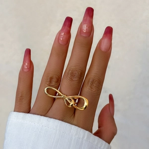 Close-up of a double-layered butterfly gold ring worn on a finger with elegant styling