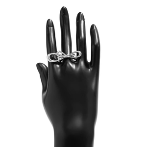 Detailed view of a polished silver bow-shaped double finger ring on a display hand