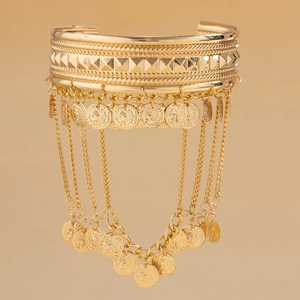 Detail of bohemian gold arm chain with hanging coins and layered metal fringes