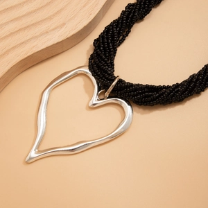 Détail du pendentif cœur argenté avec cordon de perles noires à plusieurs brins