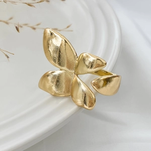 Detail of a vintage golden butterfly open ring with hammered texture on a ceramic plate