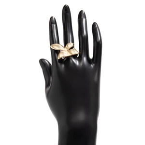 Macro shot of polished gold flower ring with four rounded petals on a black stand