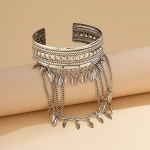 Detail of vintage silver arm cuff with metallic tassels and boho leaf charms
