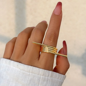 Detail shot of multi-layer gold geometric ring with architectural metal bar accent