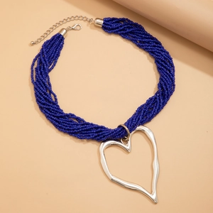Détail du collier de perles bleu marine multicouche avec pendentif cœur argenté