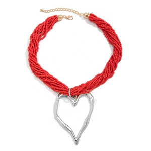 Détail du collier de perles rouges multicouches avec pendentif coeur argenté