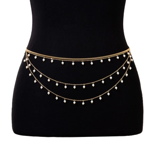 Detail of layered gold waist chain featuring delicate white pearls on a black mannequin