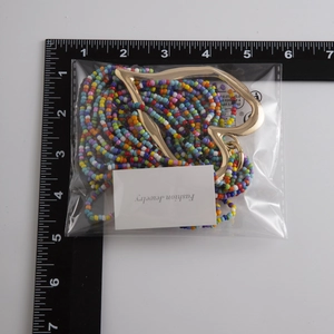 Vue détaillée du collier de perles multicolores avec grand pendentif en cœur doré