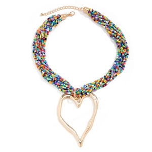 Détail d'un collier de perles bohème coloré avec un pendentif en forme de cœur doré