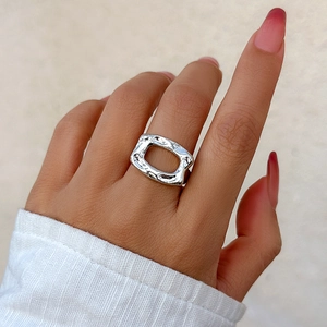Close-up of silver minimalist open rectangle ring with hammer-textured metal finish