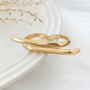 Detailed macro of gold metallic double ring with textured surface on white ceramic