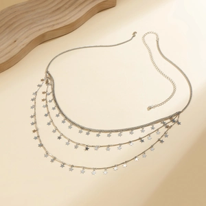 Close-up of layered silver star waist chain with metallic texture and lobster clasp