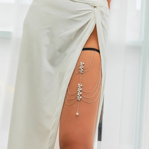 Detail of multi-layer thigh chain with silver flower accents and white pearl drop charm