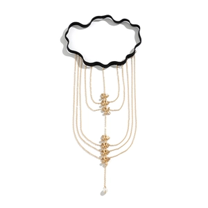 Macro view of multi-layer gold leg chain featuring butterfly pendants and a pearl drop