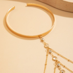 Dettaglio del choker dorato con catene a frange multistrato e strass brillanti