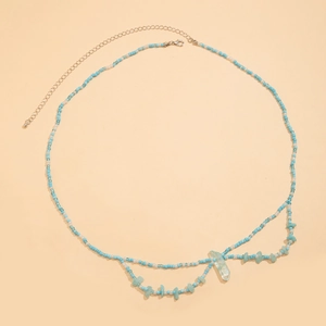 Detalle de cuentas azules y blancas con piedra irregular y colgante de prisma de cristal