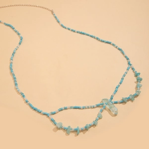 Detalle de cadena de cintura bohemia con cuentas azul cielo y colgante de cristal