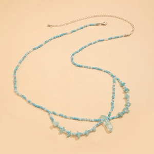 Detalle de la cadena de cintura bohemia con cuentas azules, piedras y colgante cristal