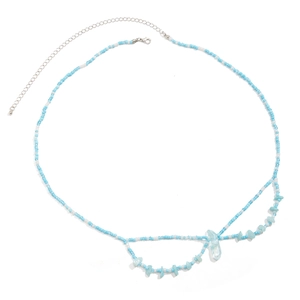 Detalle de cadena de cintura con cuentas azules y blancas, piedras y colgante de cristal