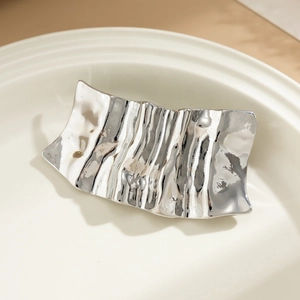 Detail showing wave textured silver metal hairpin with irregular hammered finish