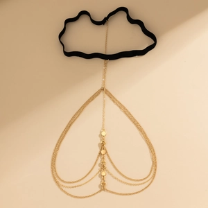 Detail of bohemian gold layered leg chain with black elastic band and metallic discs