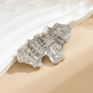 Detailed close-up of the silver irregular lava textured metal hairpin with a secure back clip
