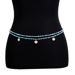 Detalle de cadena de cintura bohemia con cuentas azules y colgantes de concha en maniquí