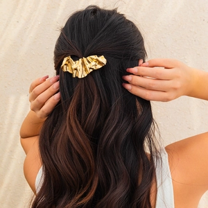 Elegant irregular gold metal hairpin with crinkled texture on brunette hair back view