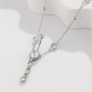 Detalle macro de cadena corporal de plata con circonitas brillantes y cuentas pulidas