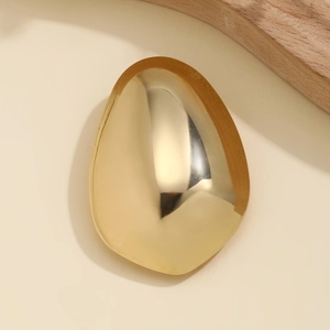 Macro shot of polished gold metallic hair clip with a smooth high-gloss mirror finish