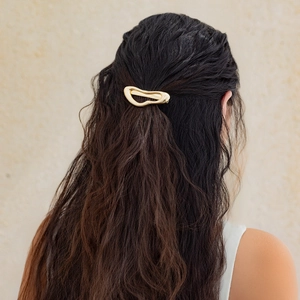 Elegant gold minimalist irregular fluid hair claw clip shown on a woman back view