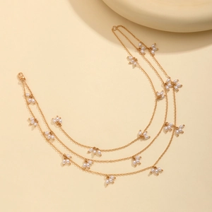 Détail d'un collier triple rang en or avec fleurs de perles en forme de gouttes