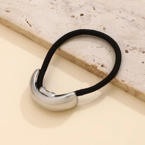 Detail of a minimalist black elastic hair tie featuring a polished silver metal buckle