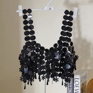 Detalle de cadena corporal con lentejuelas negras en formas redondas y de pétalos