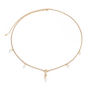 Detalle de cadena corporal dorada con pedrería brillante y elegantes perlas blancas