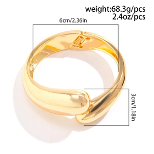 Dettaglio del bracciale rigido dorato irregolare con misure di 6 cm di diametro e larghezza