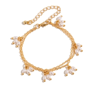 Détail d'un collier double rang doré avec pendentifs en grappes de perles blanches
