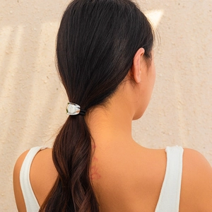 Close-up of a silver irregular crinkled metal hair tie worn on a ponytail