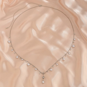 Primer plano detallado de cadena de plata con perlas elegantes y pedrería brillante