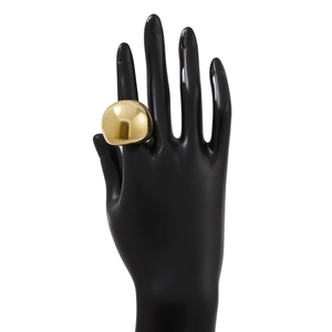 Gros plan d'une grande bague dôme dorée en lave liquide avec surface polie miroir