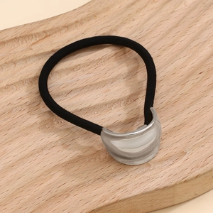 Macro detail of elastic hair tie featuring a glossy silver curved metallic ornament