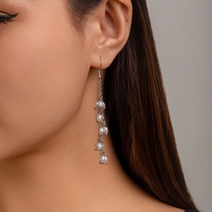 Boucles d'oreilles pendantes argentées avec perles sur un mannequin féminin