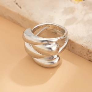 Macro shot of liquid metal style layered ring with polished silver finish on marble