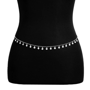 Detalle de una cadena de plata para la cintura con perlas blancas en un maniquí negro