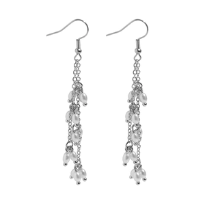 Détail de boucles d'oreilles pendantes argentées avec perles blanches élégantes