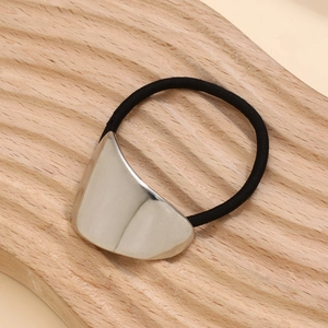 Detailed close-up of a silver curved metal piece on a black elastic hair tie hairpin
