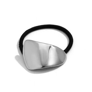 Detail of silver geometric irregular metal hair clip with black elastic band on white background