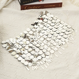 Detalle de cadena corporal con lentejuelas plateadas efecto espejo y flores de metal