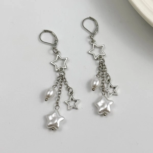 Boucles d'oreilles étoile en argent avec perles blanches et pompons sur fond gris